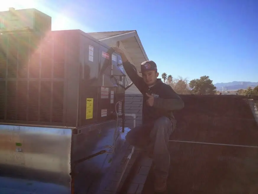 HVAC technician performing Boiler Repair on a rooftop unit in Bristol